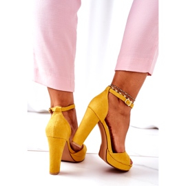 Sandali in pelle scamosciata femminile sul post giallo 1